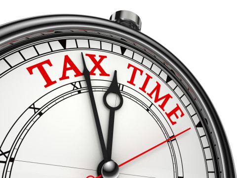 Tax time concept clock closeup isolated on white background with red and black words